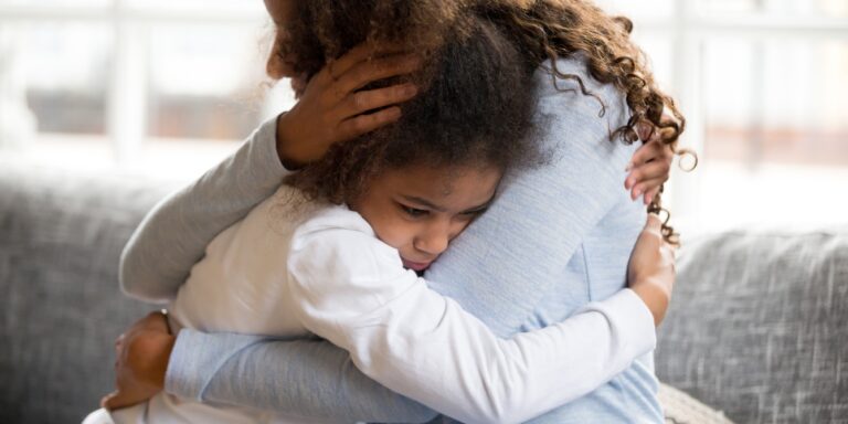 worried young girl hugging mother